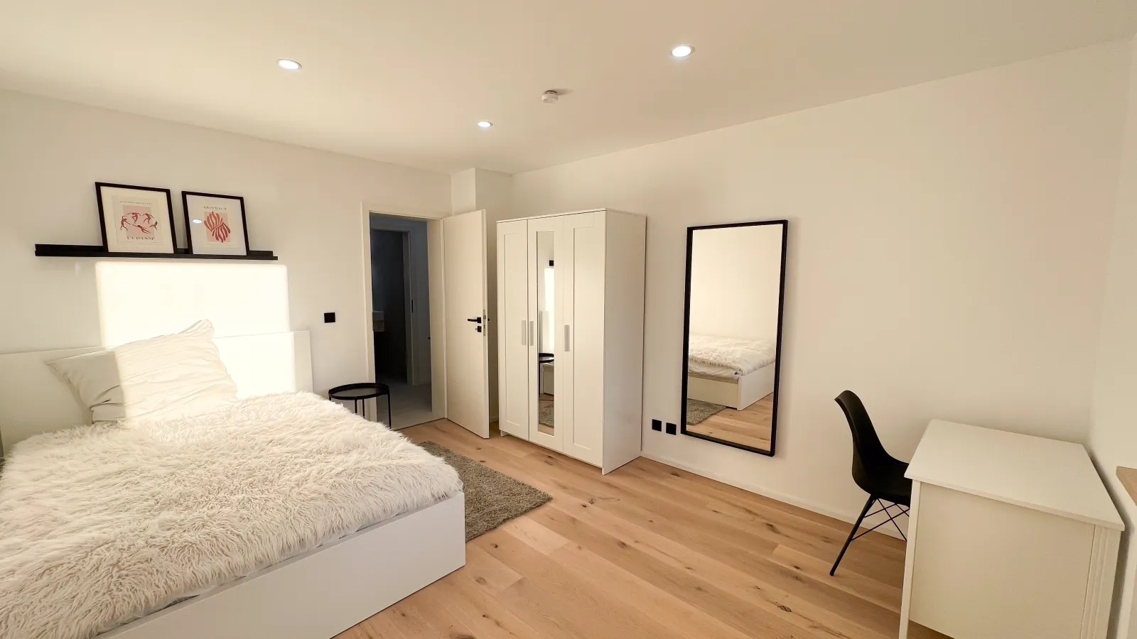 Saniertes, möbliertes Co-Living-Zimmer mit Bett, Schreibtisch und Spiegel